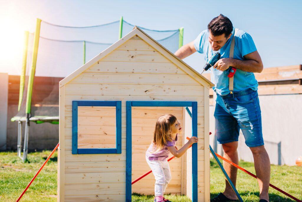 Ein Vater baut mit seiner Tochter ein Spielehaus