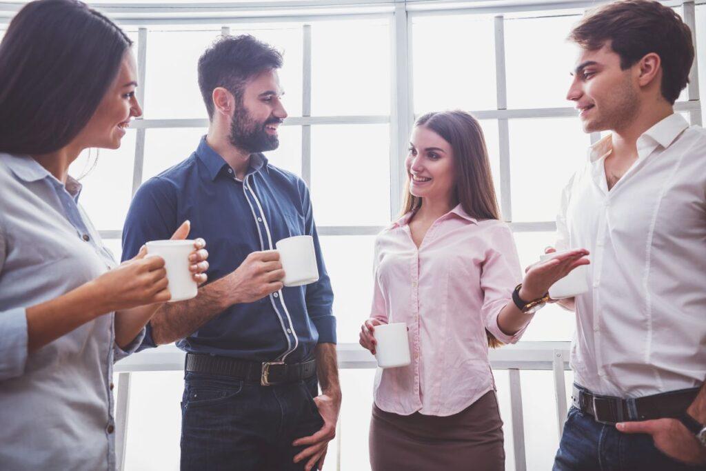 Gruppe von Mitarbeitern im Gespräch bei Kaffeepause – Austausch über Employer Branding mit Unterstützung einer Agentur