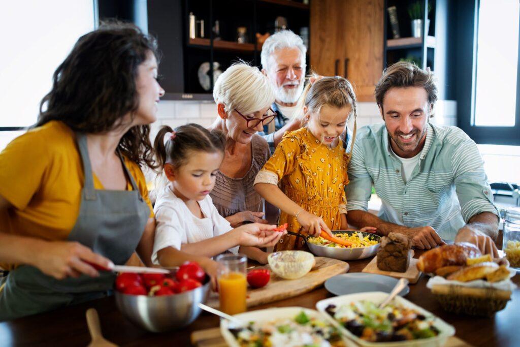 Familie bereitet gemeinsam eine Mahlzeit in der Küche zu.