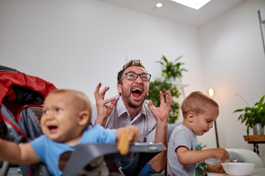 Gestresster Vater mit zwei Kindern im Wohnzimmer | Base Liquid